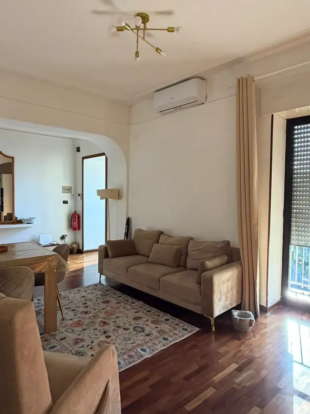BookNoFees tatil evi: Castellammare Di Stabia – Bej renkli kanepe, desenli halı ve pirinç armatürlü tavan vantilatörü bulunan oturma odası