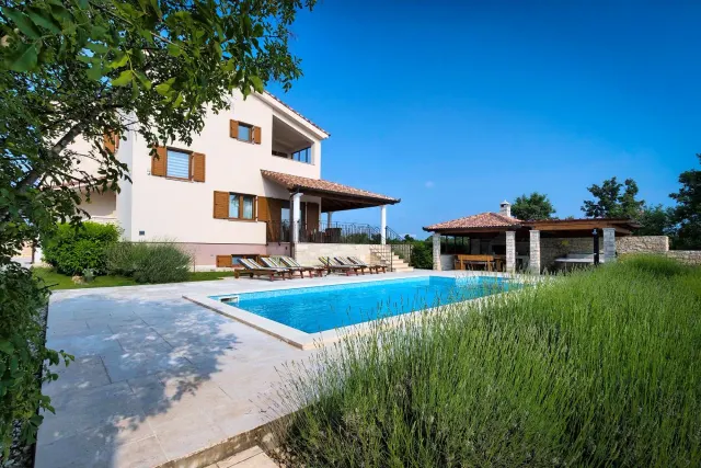 BookNoFees tatil evi: Štokovci – Štokovci’deki Villa Stokovci’de, bir evin önünde yer alan yüzme havuzlu bir villa