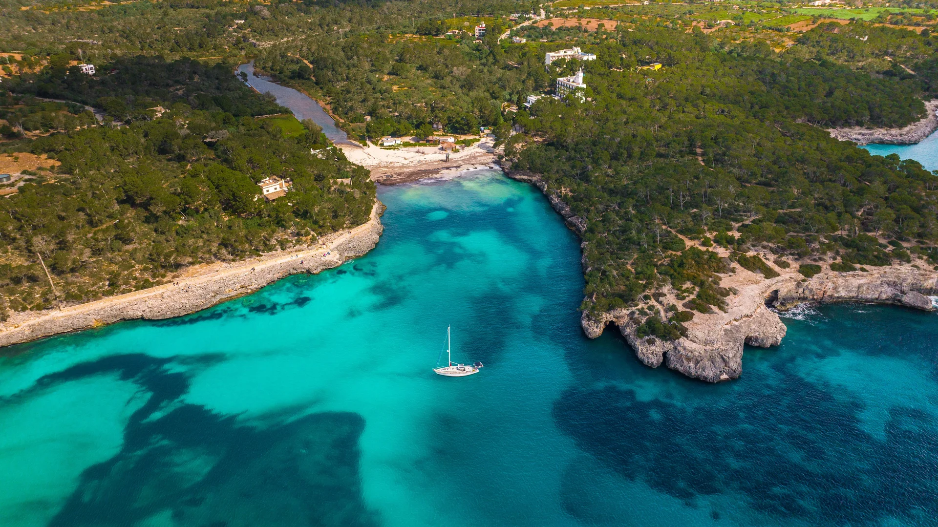 Mallorca'da turkuaz renkli suları olan bir kaya koyunun havadan çekilmiş fotoğrafı