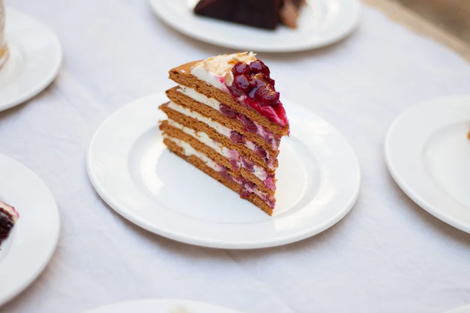 Example photo: A slice of layered cake topped with berries on a white plate