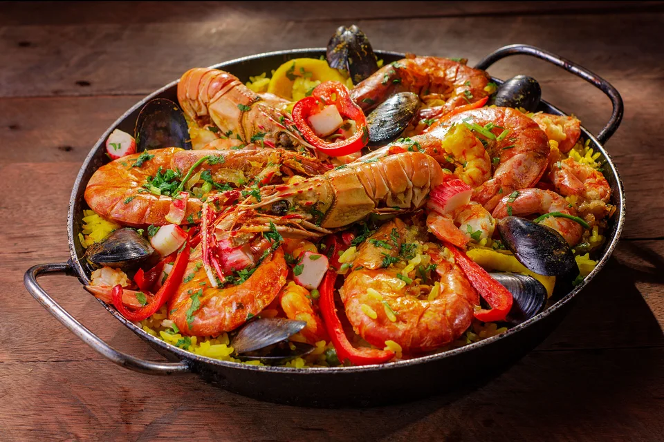 Example photo: A pan of seafood paella topped with shellfish and red peppers